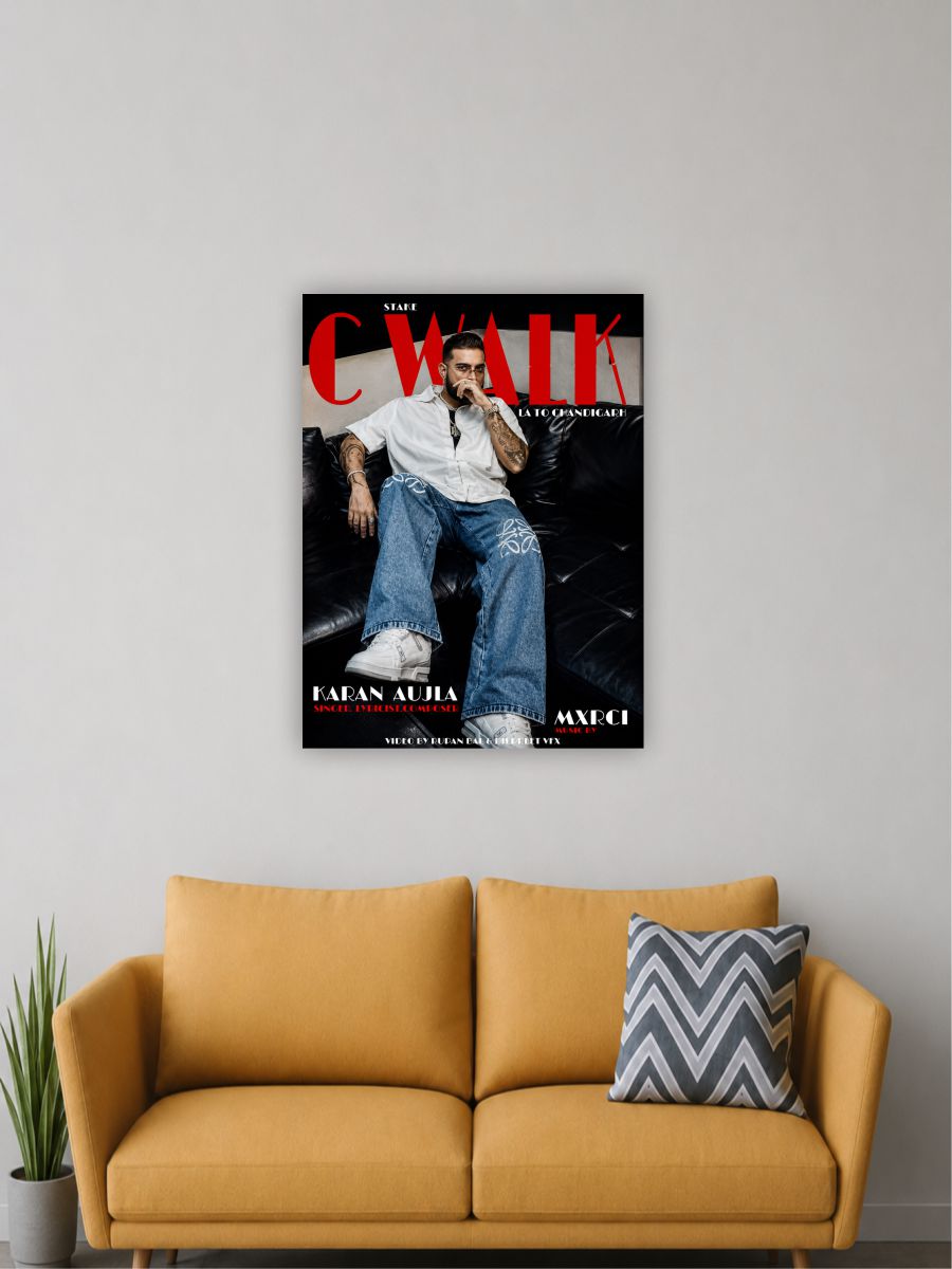 A framed wall poster featuring a magazine-style cover portrait hangs above a mustard yellow sofa in a living room setting. The poster includes large red 'C WALK' text and a seated person in jeans and a white shirt.
