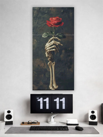 Artistic depiction of a skeleton hand holding a red rose above a computer setup with a digital clock.