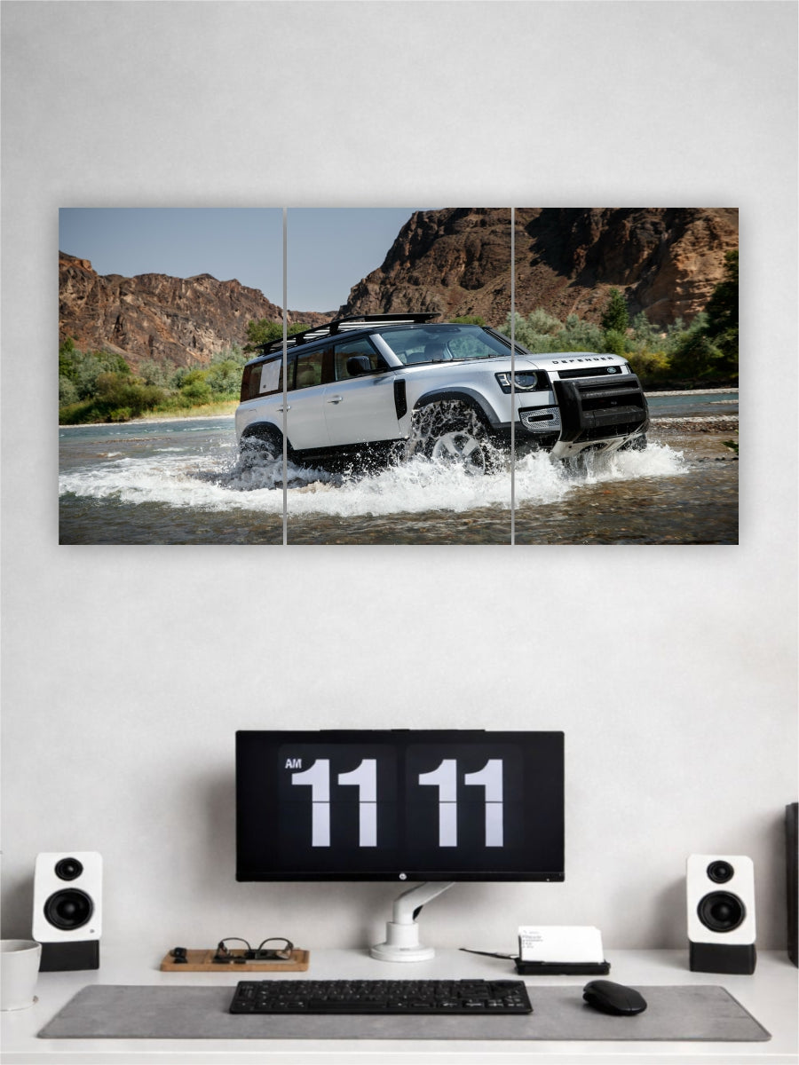 Wall art of a white SUV driving through water with a computer setup below on a gray desk.