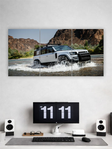 Wall art of a white SUV driving through water with a computer setup below on a gray desk.